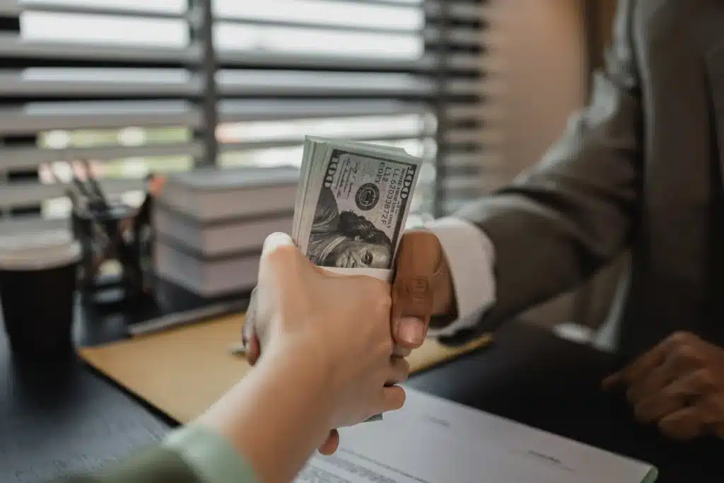 Man shaking womens hand while handing her money