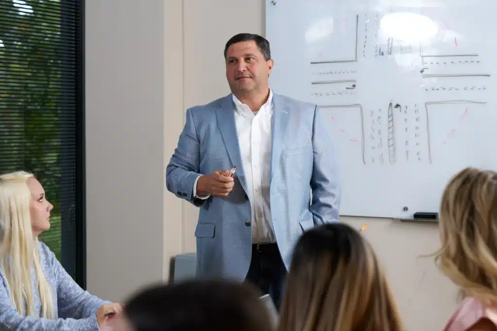 Steven Mezrano presenting case details to staff at Mezrano® Law Firm