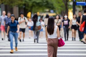 Woman crosses the traffic lane in the city