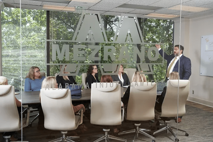 Blurred background of Mezrano Law Firm conference room with Steven Mezrano talking to staff members