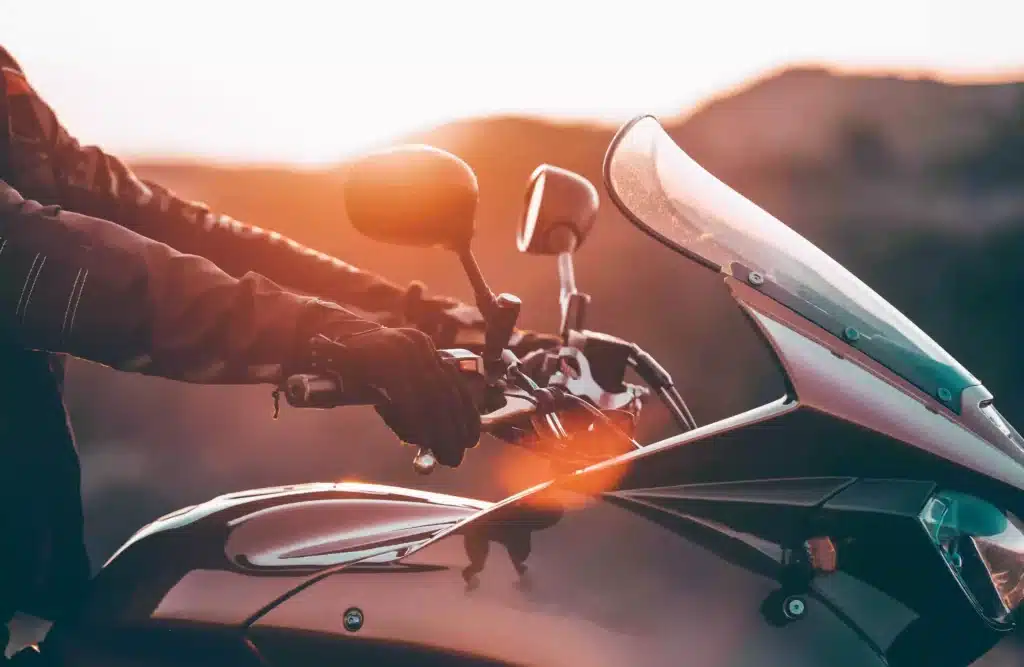 Closeup of motorcycle rider holding handle bars while driving