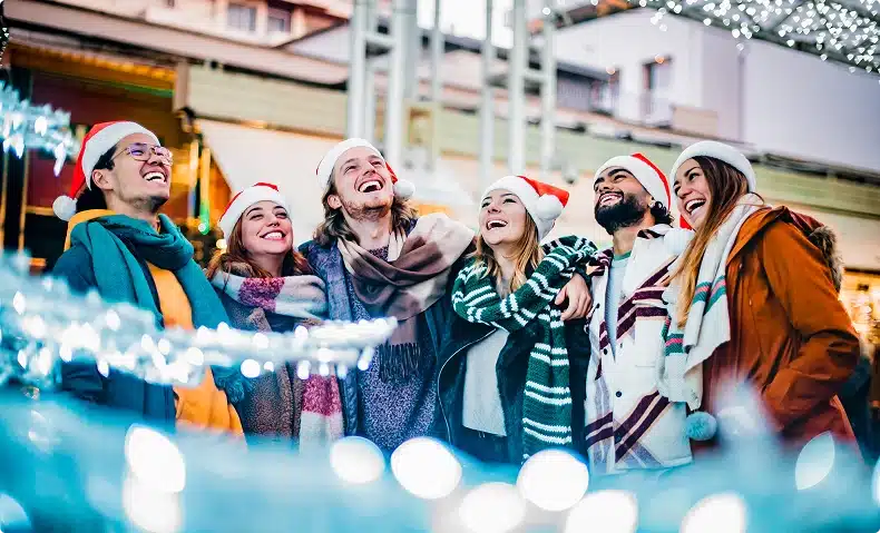 Friends hugging around Christmas themed event