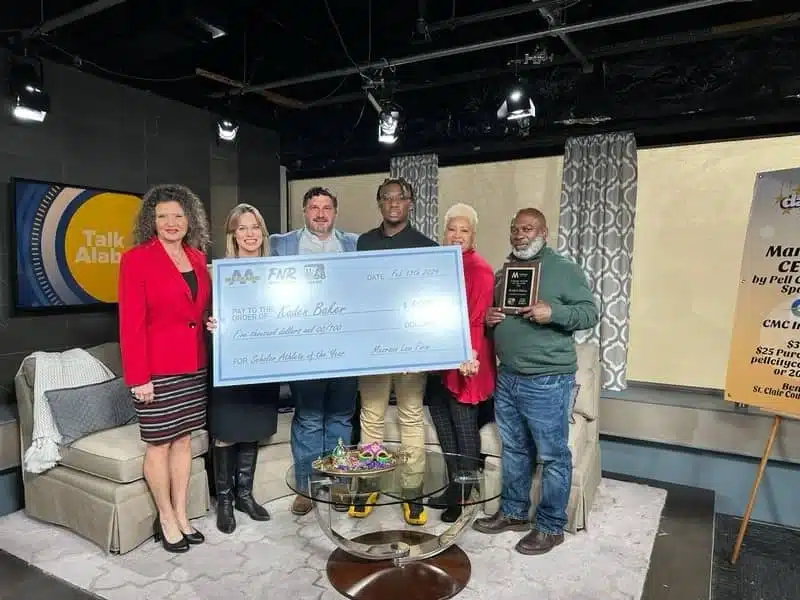 Steven Mezrano standing with a family receiving a settlement check