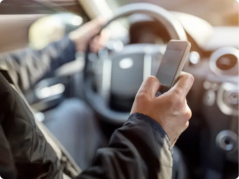 Man driving while texting on cell phone